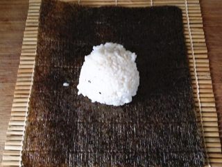 7、什锦火腿寿司,准备好寿司竹帘，平铺一片紫菜再放上拌好的饭团