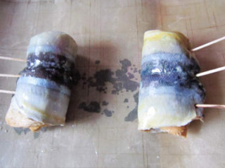 7、烤秋刀鱼吐司手卷,放如铺好油纸的烤盘中，表面刷上一层薄油