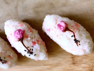 12、日式手鞠壽司飯團,快速將米飯捏成所需形狀，放一朵櫻花和芝麻做裝飾。