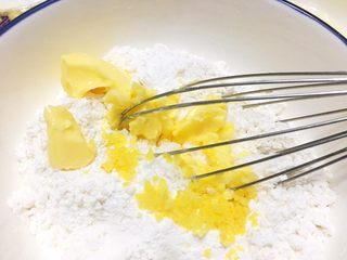 5、柠檬司康,所有的粉，混合，加入黄油。柠檬屑（一般是一个柠檬屑的一半），柠檬屑能带来特别的柠檬清香。