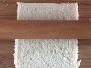 3、懒人寿司面包卷,用擀面杖将面包片压实
