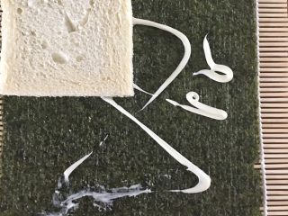 4、懒人寿司面包卷,在海苔上挤上沙拉酱，将面包片依次放上去。（沙拉酱是让面包片与海苔相粘连）