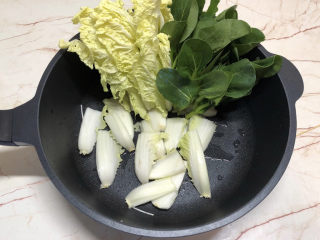 2、牛肉火锅,将娃娃菜切成条放入锅内,再放上一些小青菜。