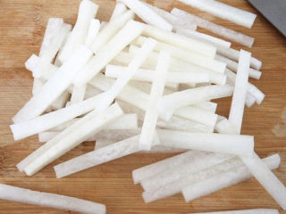 4、牛肉火锅,将白萝卜切成条。