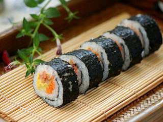 9、韩式紫菜包饭,去掉竹帘，在干净的刀上沾水， 将紫菜包饭切成合适的大小即成 。吃时，配上甜辣酱或寿司酱油 都行。