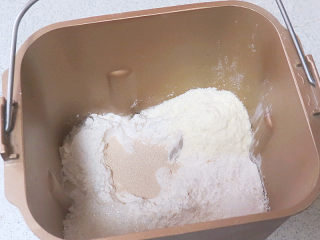 1、经典软餐包【黄油面包卷】,将除黄油外的所有材料按先液体后粉类秩序放入面包机桶内