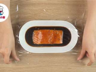 2、烤箱版红烧鱼盖饭,三文鱼块300g淋上酱汁抹匀,盖上保鲜膜,放入冰箱冷藏腌制2小时