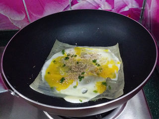 5、烤冷面,用将鸡蛋液用锅铲摊开、再撒些芝麻和葱花