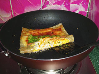 9、烤冷面,用锅铲将冷面底层铲起折叠