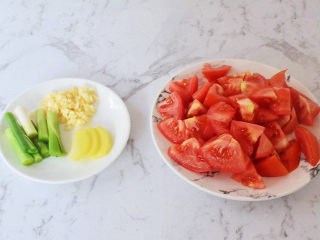 2、番茄火锅,将番茄洗净切成小块，切碎更好，蒜切末，姜切片，大葱切寸段