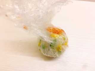 13、凤尾虾饭团,将保鲜膜包起收紧，捏成饭团，露出虾尾部分，打开即可