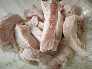 3、#糖醋菜#家常糖醋里脊,然后加入适量淀粉，每一条里脊肉都裹上淀粉。