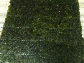 10、鳕鱼肉松寿司,取一片海苔放在配套的工具主席上，海苔光面向下，粗糙的一面向上摆放