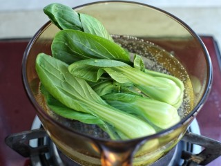 8、电饭煲腊肠煲仔饭,锅中烧开水放入洗净的油菜