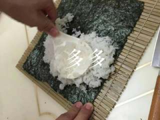 4、自制寿司,竹度洗净控干埔底，紫菜放首层，米饭适量埔在紫菜上，稍压平，使其与紫菜粘合！