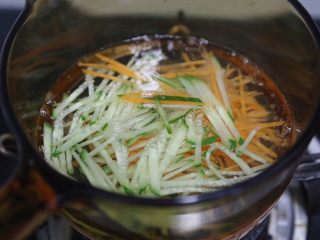 3、麻酱凉面,取一个小锅，烧滚水后放入黄瓜和胡萝卜丝