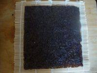 5、蒸玉米胡萝卜紫菜肉卷,准备寿司卷帘，将紫菜铺在上面