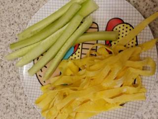 3、紫菜包饭,将黄瓜、做好的鸡蛋饼以及火腿全部切条