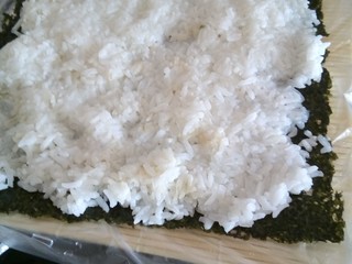7、寿司,在寿司帘铺上海苔再铺上米饭，为不沾手沾点水