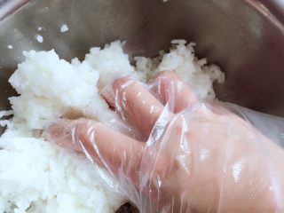 3、紫菜包饭,将寿司醋适量加入米饭中，戴上一次性手套抓饭
