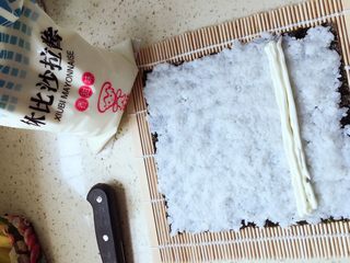 8、紫菜包饭,把铺好的紫菜饭团张放在竹帘上，挤上沙拉酱(如果喜欢沙拉酱可以多挤上一些，我本人比较喜欢)