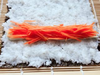 9、紫菜包饭,把待用的胡萝卜丝放上