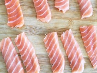 1、三文鱼握寿司,将三文鱼肉片成大小适中的薄片。