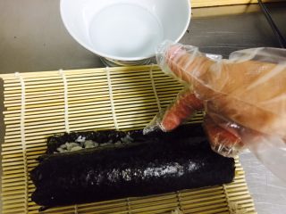 8、????木鱼花寿司????,从靠近身体这边卷起 卷到尾部时 把紫菜边缘 抹上一点点水。看图 这样边缘会贴合的很紧密 看似无缝隙