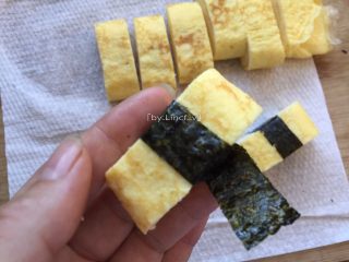 15、寿司玉子烧,把剪好的海苔条绕着玉子烧中间围绕一圈即可