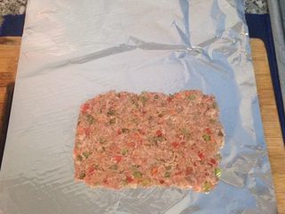 6、西班牙肉卷 Embotido,鋁箔紙舖平，再舖上一層混勻調好料的絞肉(長度請先測量您的蒸鍋直徑)。