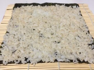 15、酱香味秋葵寿司(纯素版),把拌好的米饭均匀的铺在海苔上