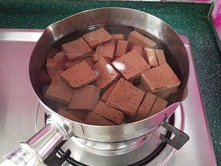 2、韩式海鲜锅,鸭血切块放入锅中、加食盐、料酒和清水煮沸、去腥的同时可增加嫩滑口感