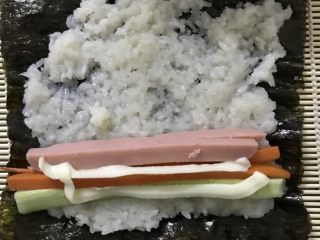 8、寿司,把(火腿肠，胡萝卜，黄瓜，沙拉酱)所有料放上然后卷起来，卷紧！
