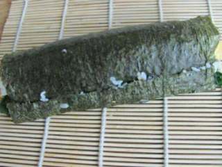 6、水滴寿司,然后用卷帘卷起，卷到最后的时候按压下去，卷边用米饭粘牢。