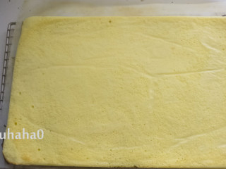 11、百香果旋涡蛋糕,烘烤结束取出烤盘，提着油纸将蛋糕倒扣在网架上，撕掉蛋糕底部的油纸，将蛋糕放凉