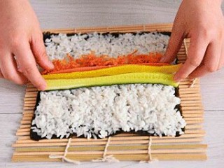 4、寿司,中间分别放一根火腿条，黄瓜和萝卜条，肉松撒5克铺成一条。