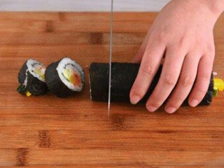 9、寿司,在案板上用刀切成片即可。