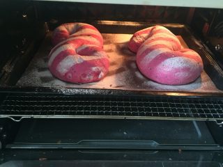 11、火之舞（火龙果）奶酪软欧包,发酵好的面团用纸板刻出镂空横纹，撒粉装饰后入烤箱，上火210.下火180烤15分钟，也可以上下火190度烤15～17分钟，烤5分钟后加盖锡纸避免上色严重