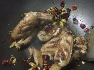 15、香辣鸡翅????土豆条,倒入鸡翅翻炒出香味，让每一块鸡翅都粘上酱料。