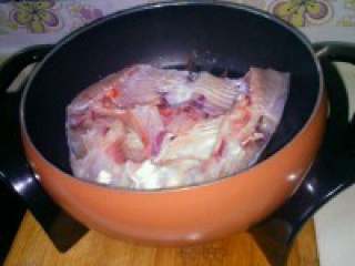 3、自制【鱼头豆腐火锅】,锅烧热，倒适量多些的油，把鱼 头放入中火慢煎。