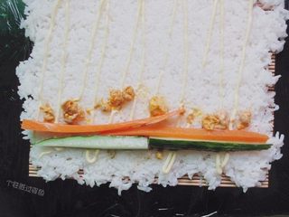 12、手卷饭团,放入腌好的黄瓜条胡萝卜条，咸蛋黄稍稍掰碎放入