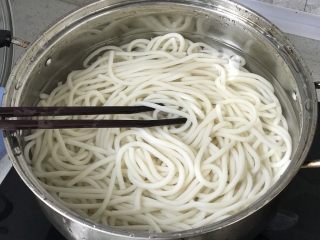 4、新疆炒米粉(家庭版),捞出米粉用凉水冲掉表面米浆,再把米粉倒进凉水中浸泡备用;