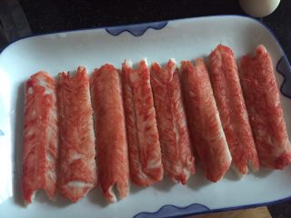 1、紫菜包饭,先把冰冻蟹柳条隔水加热