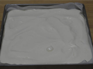 6、紫菜肉松蛋糕卷,将蛋清和蛋黄糊混合均匀后倒入铺了油纸的烤盘里，表面刮平，用力震出气泡