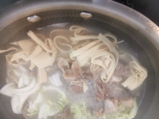 8、羊肉火锅,将骨头,肉和汤倒入锅中,加入干豆腐,盐