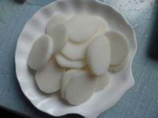 11、自制【养生菌菇火锅】,准备好的年糕切成片。