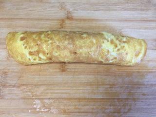 10、早餐鸡蛋卷,将蛋饼由下向上卷起,稍卷的紧一点。