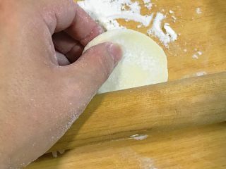 21、年夜饭+韭菜猪肉馅饺子详解,拉住面胚子的一头，一边擀一边转，就成饺子皮了。