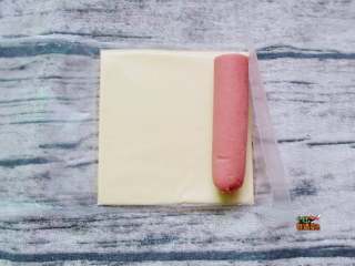 2、芝士拉丝热狗棒,把火腿肠放在芝士片上