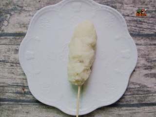 6、芝士拉丝热狗棒,将火腿芝士裹上土豆泥，用手捏成棍状，要把芝士都裹在土豆泥里